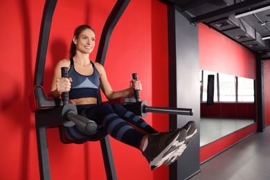Woman training on power tower in gym