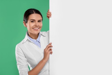 Ophthalmologist with blank banner on green background, space for text