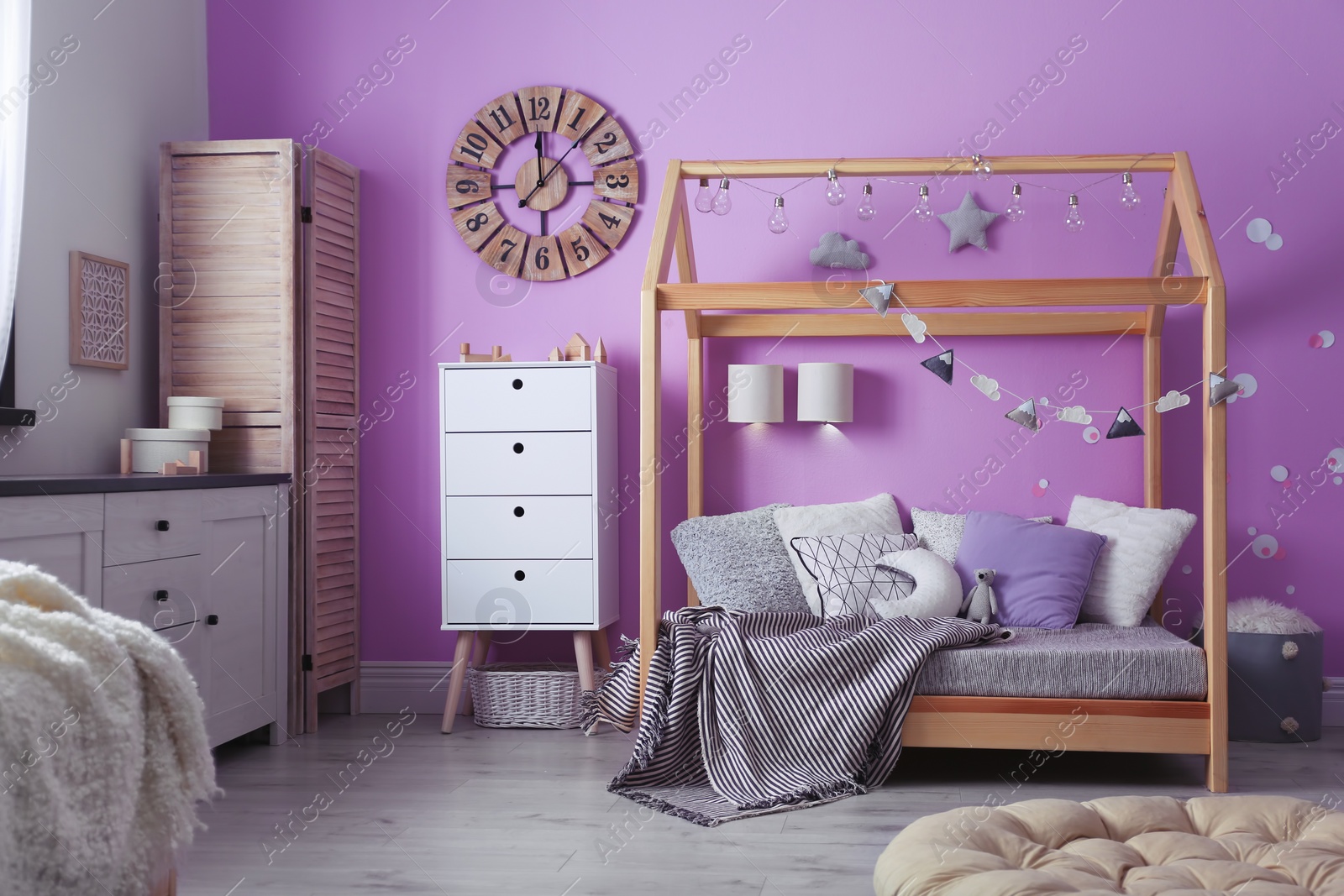 Photo of Child's room interior with comfortable bed and garland