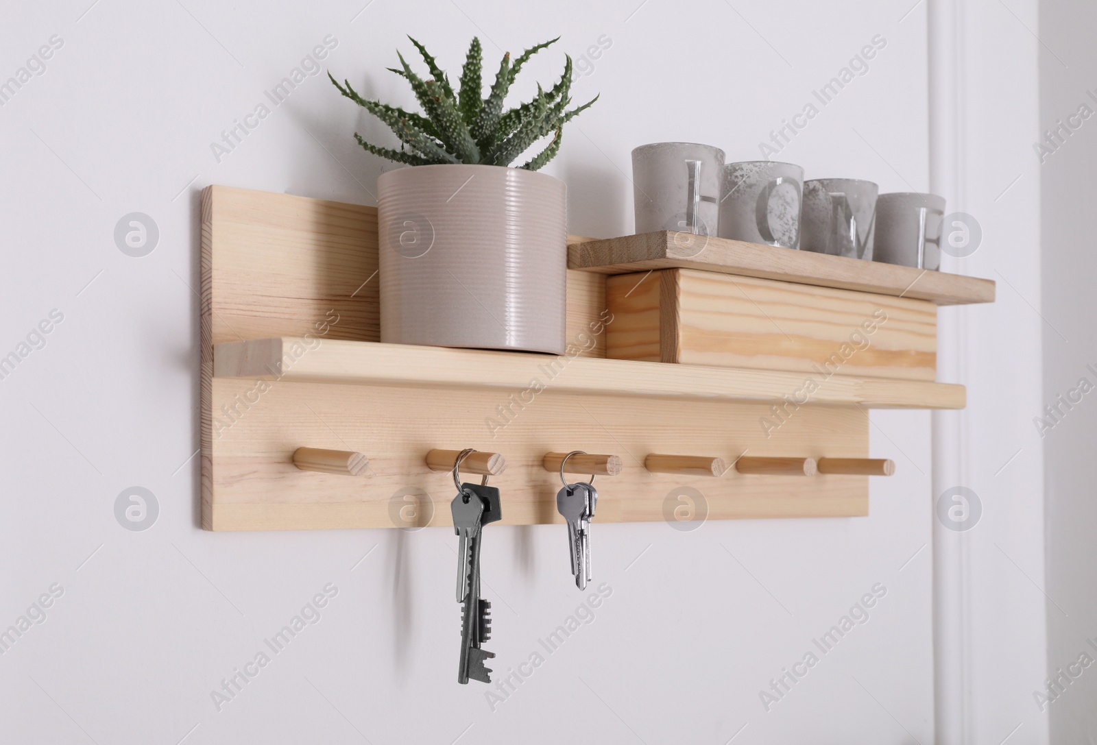 Photo of Wooden hanger for keys with decor on white wall