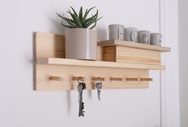 Photo of Wooden hanger for keys with decor on white wall