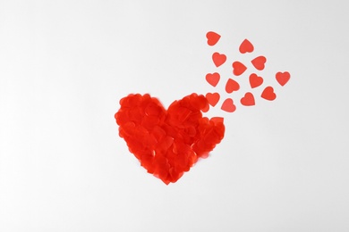 Composition with decorative red hearts on white background, top view