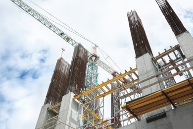 Photo of Construction site with modern tower crane, low angle view