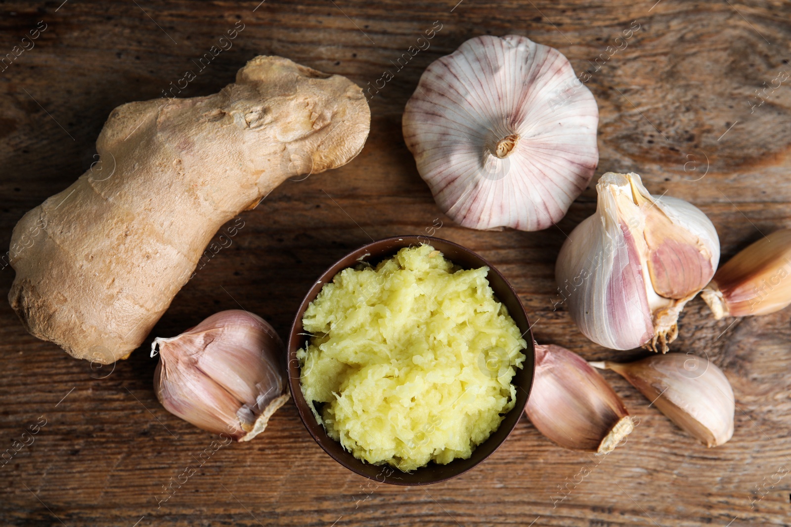 Photo of Fresh garlic and ginger on wooden table, flat lay. Natural cold remedies