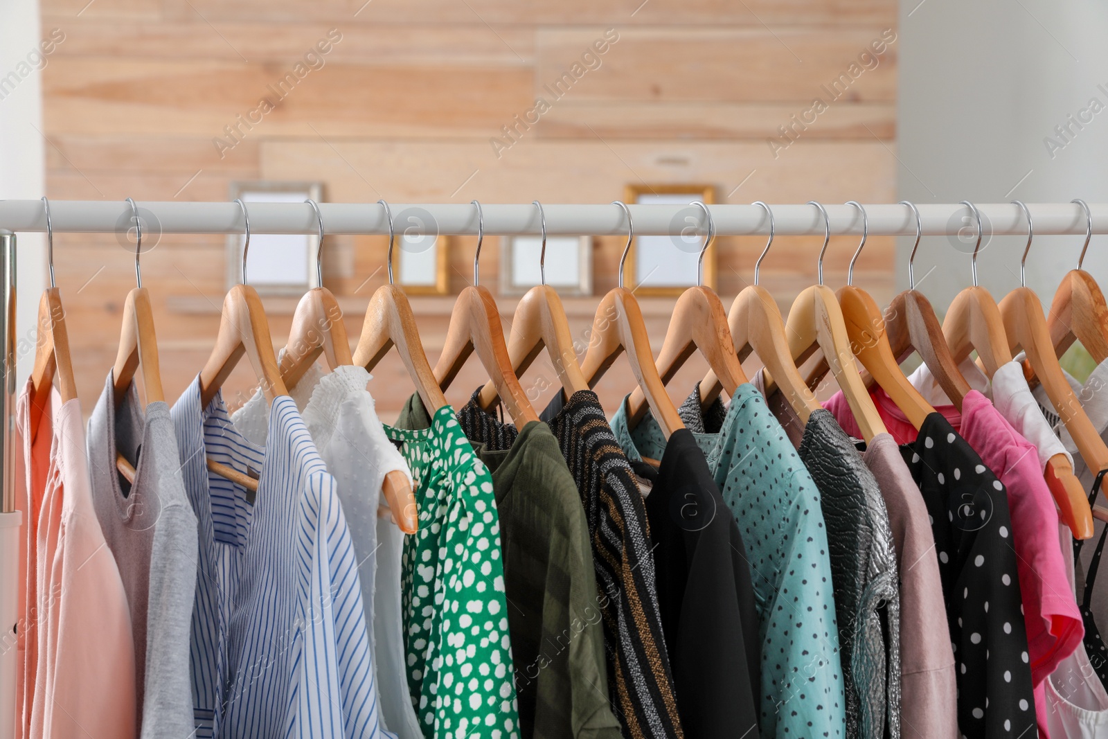 Photo of Wardrobe rack with stylish female clothes indoors