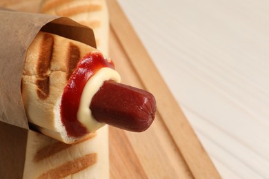 Photo of Delicious french hot dogs on white wooden table, closeup. Space for text