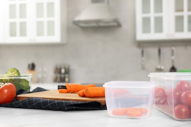 Containers with different fresh products on white marble table in kitchen, space for text. Food storage