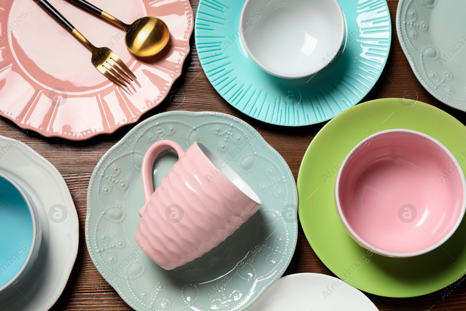 Photo of Beautiful ceramic dishware, cup and cutlery on wooden table, flat lay