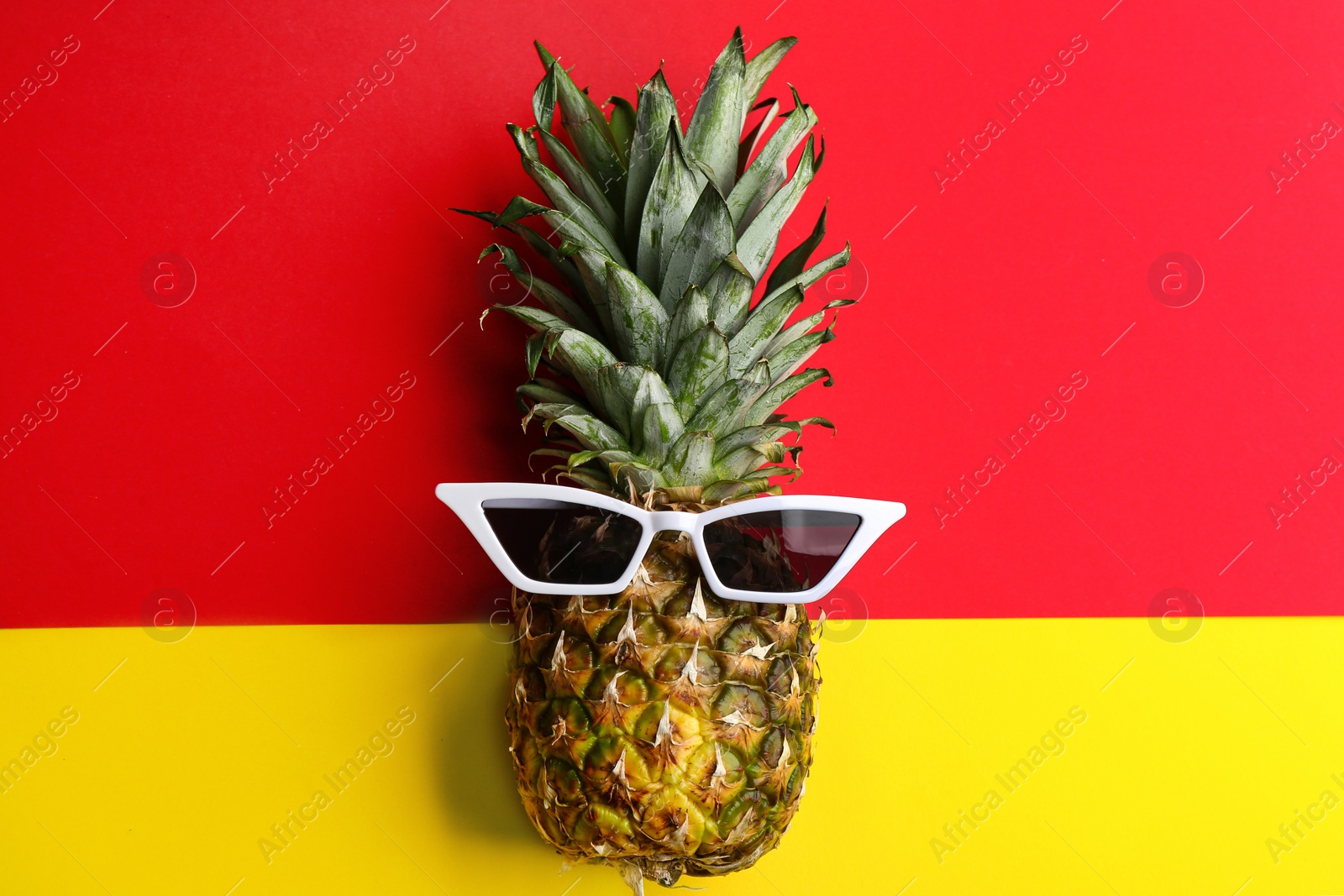 Photo of Funny face made of pineapple and sunglasses on color background, top view. Vacation time