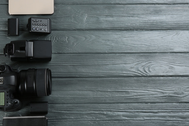 Flat lay composition with equipment for professional photographer on grey wooden table. Space for text