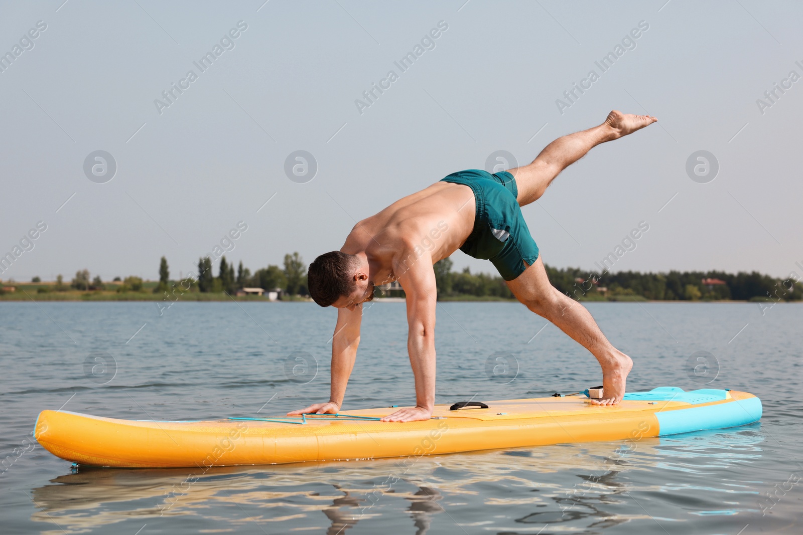 Photo of Man practicing yoga on SUP board on river