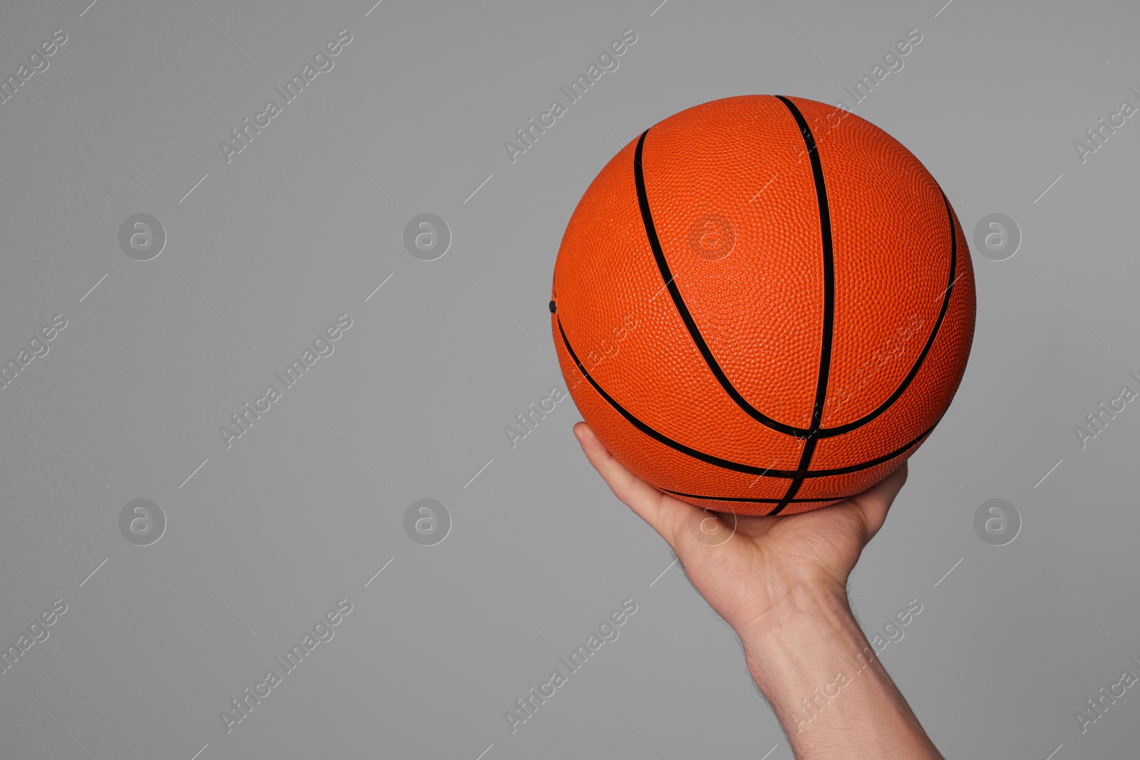 Photo of Man with basketball ball on light grey background, closeup. Space for text