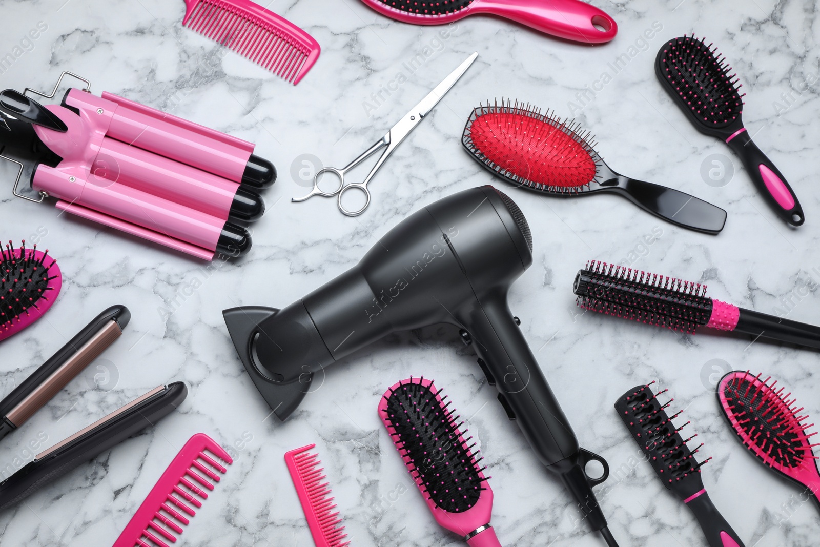 Photo of Flat lay composition of different professional hairdresser tools on white marble table