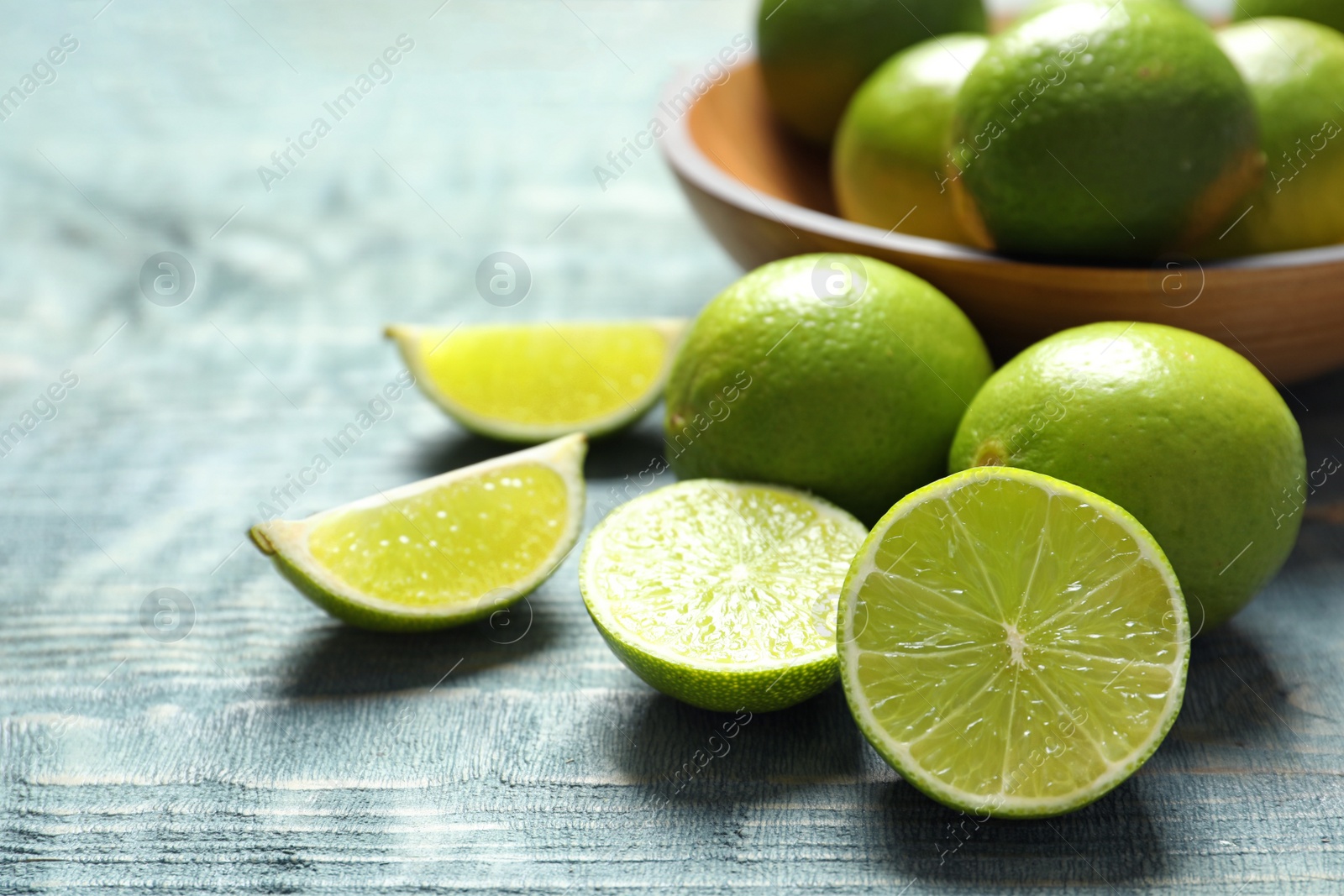 Photo of Fresh ripe limes on wooden table. Citrus fruit