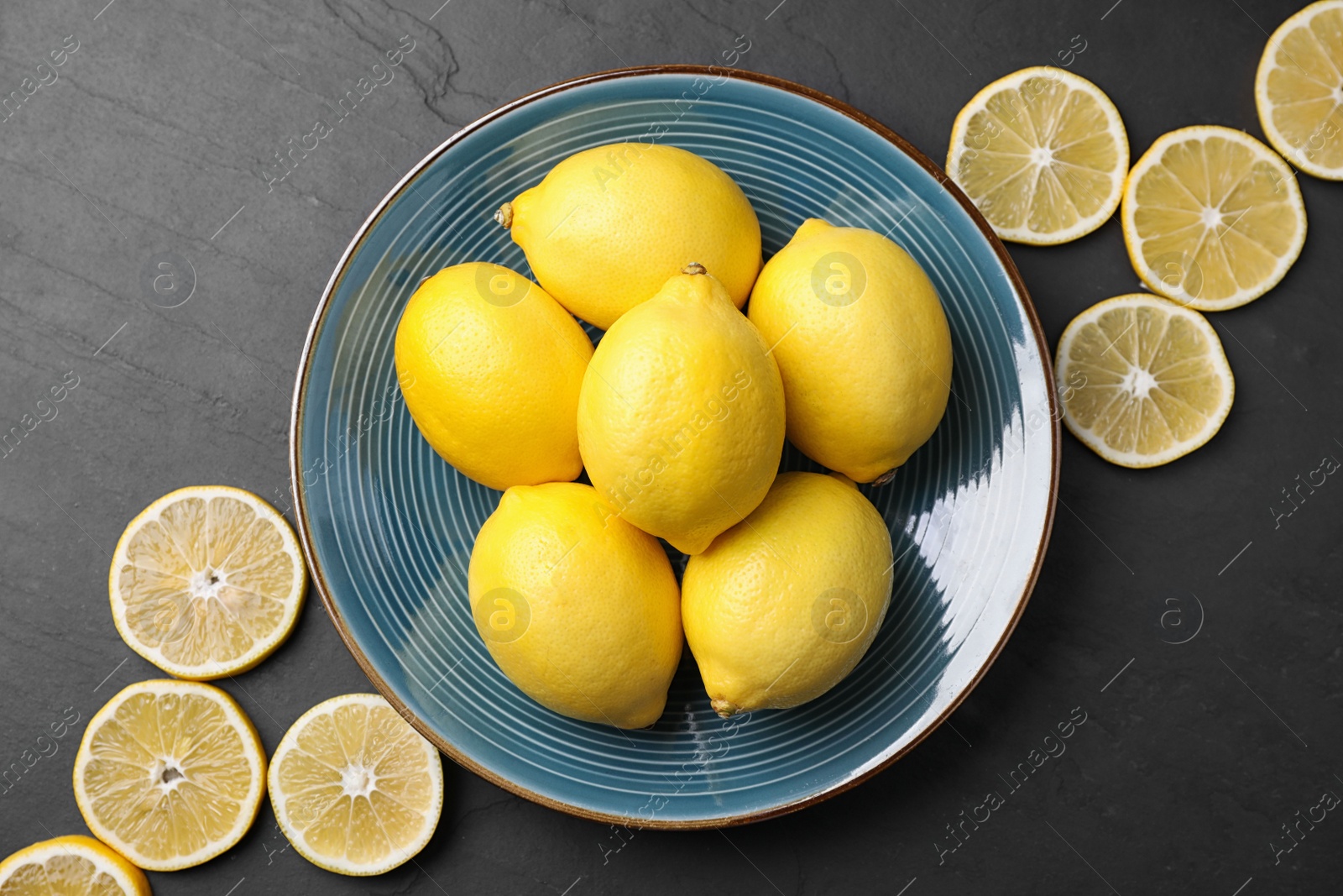 Photo of Flat lay composition with fresh ripe lemons on dark table