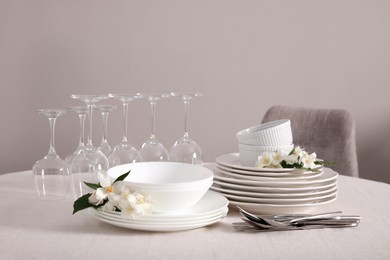 Photo of Set of clean dishware, cutlery and wine glasses on table indoors