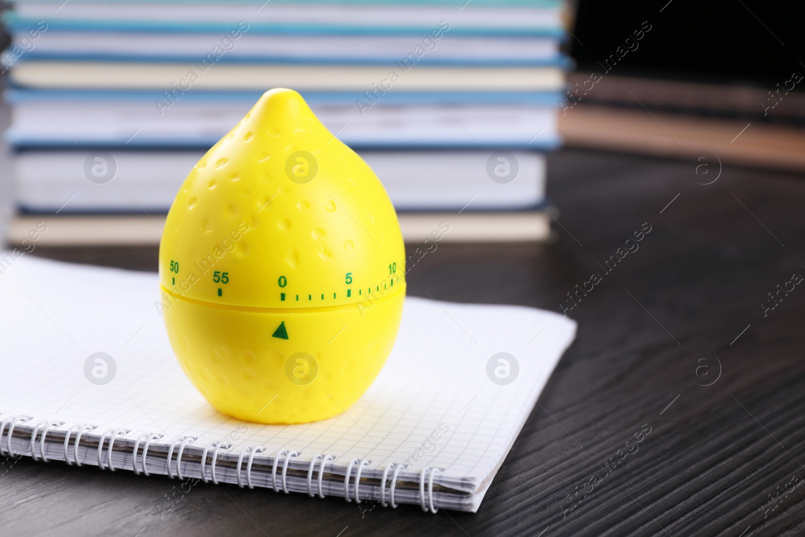 Photo of Kitchen timer in shape of lemon and notebook on wooden table, closeup. Space for text