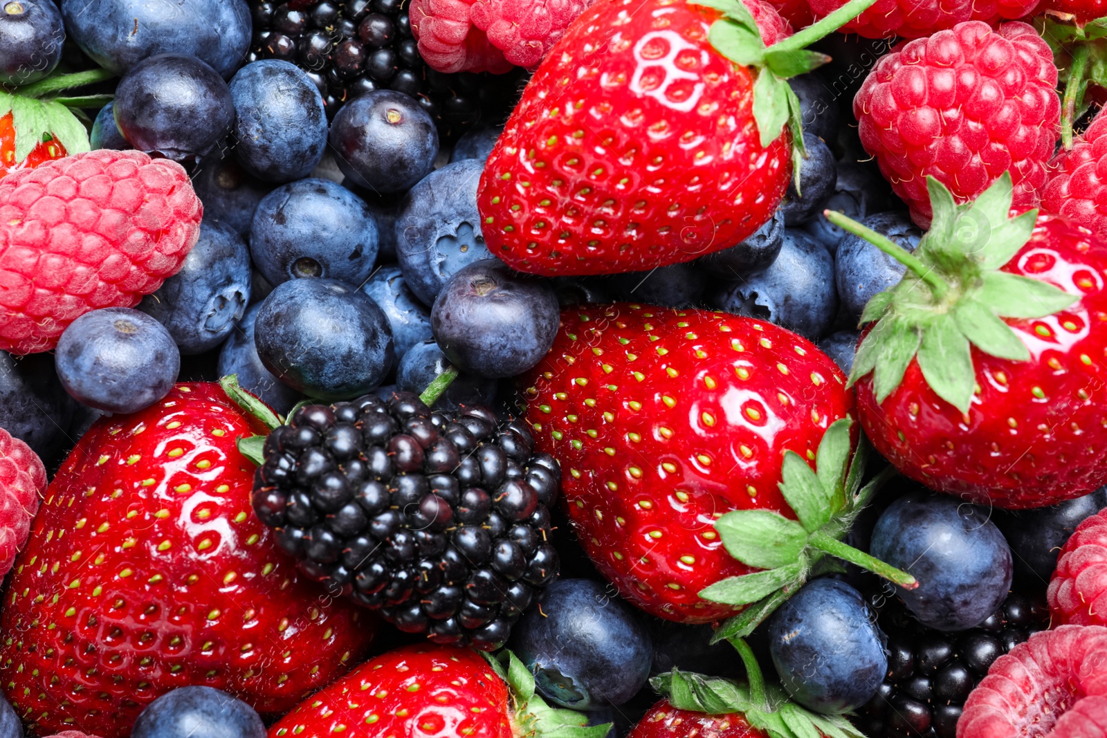 Photo of Mix of different ripe tasty berries as background, top view