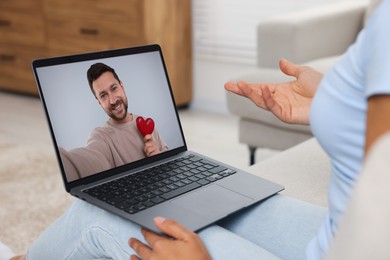 Long distance love. Woman having video chat with her boyfriend via laptop at home, closeup