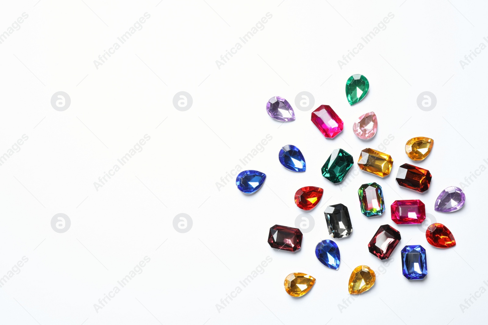 Photo of Different beautiful gemstones on white background, top view