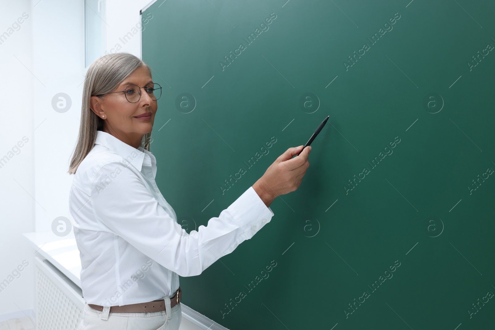 Photo of Professor explaining something at blackboard in classroom, space for text