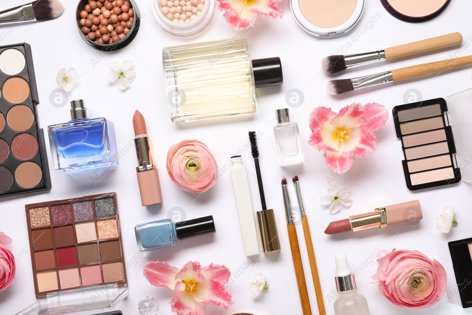 Photo of Flat lay composition with different makeup products and beautiful spring flowers on white background