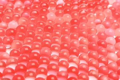 Closeup view of red vase filler as background. Water beads