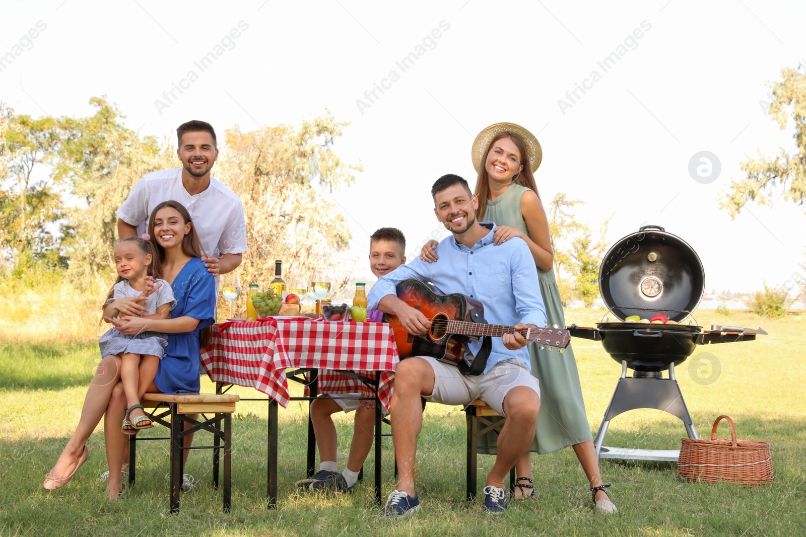 Photo of Happy families with little children having picnic in park