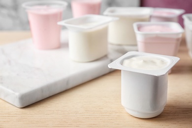 Plastic cup with tasty yogurt on table