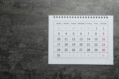 Photo of Paper calendar on grey stone background, top view. Space for text
