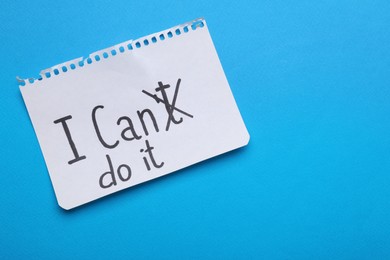 Photo of Motivation concept. Changing phrase from I Can't Do It into I Can Do It by crossing out letter T on light blue background, top view. Space for text