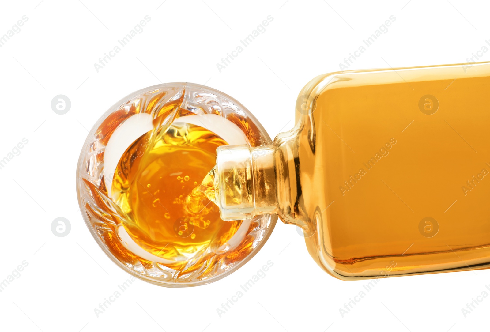 Photo of Pouring expensive whiskey into glass on white background, top view