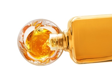 Pouring expensive whiskey into glass on white background, top view