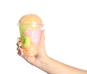 Photo of Young woman holding plastic cup with cotton candy on white background, closeup