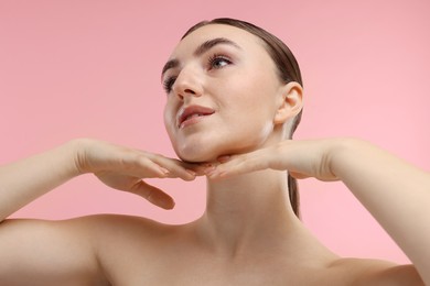 Photo of Beautiful woman touching her chin on pink background