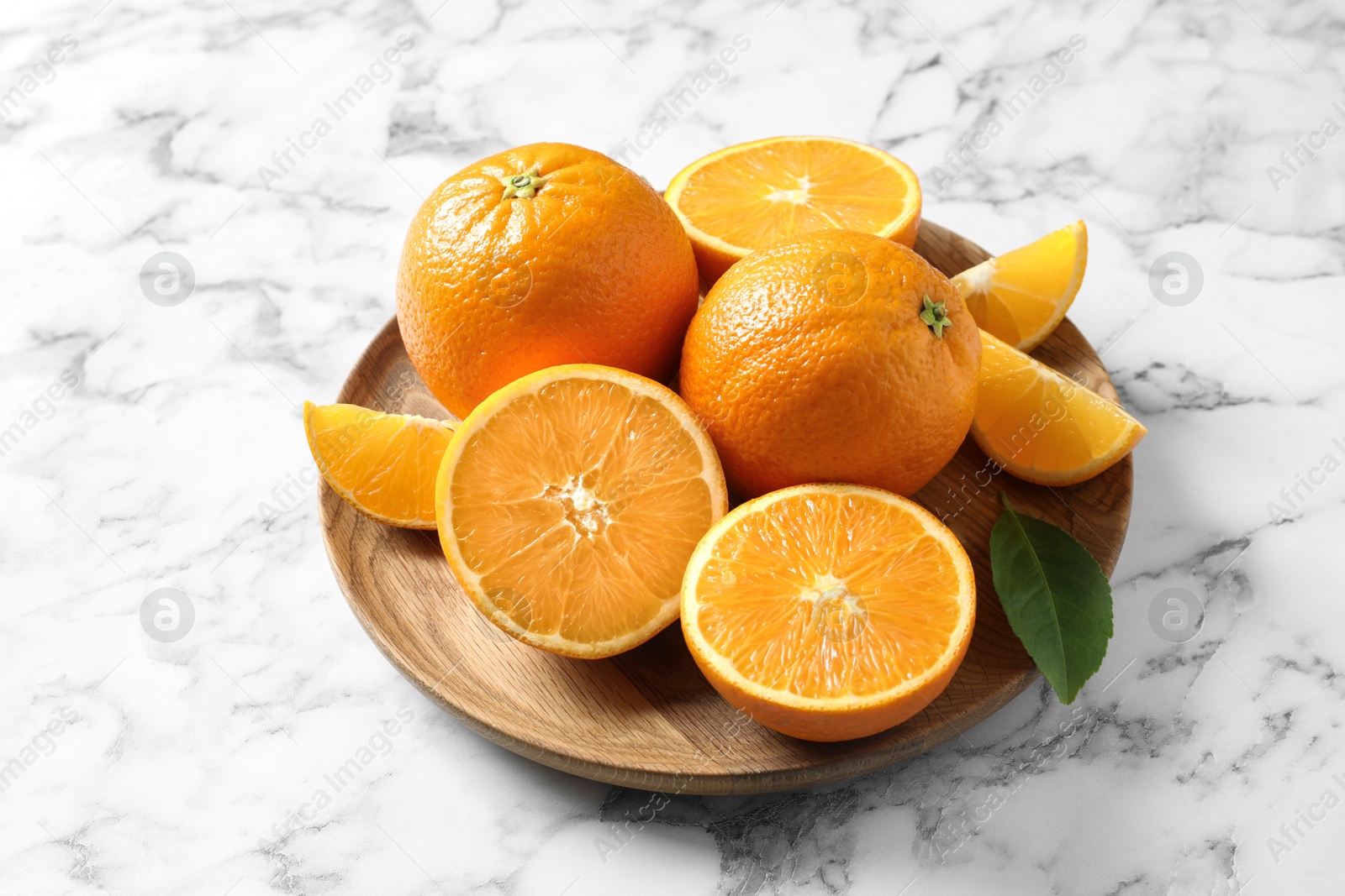 Photo of Plate with ripe oranges on marble background