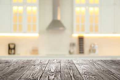 Empty wooden table and blurred view of stylish kitchen interior. Mockup for design