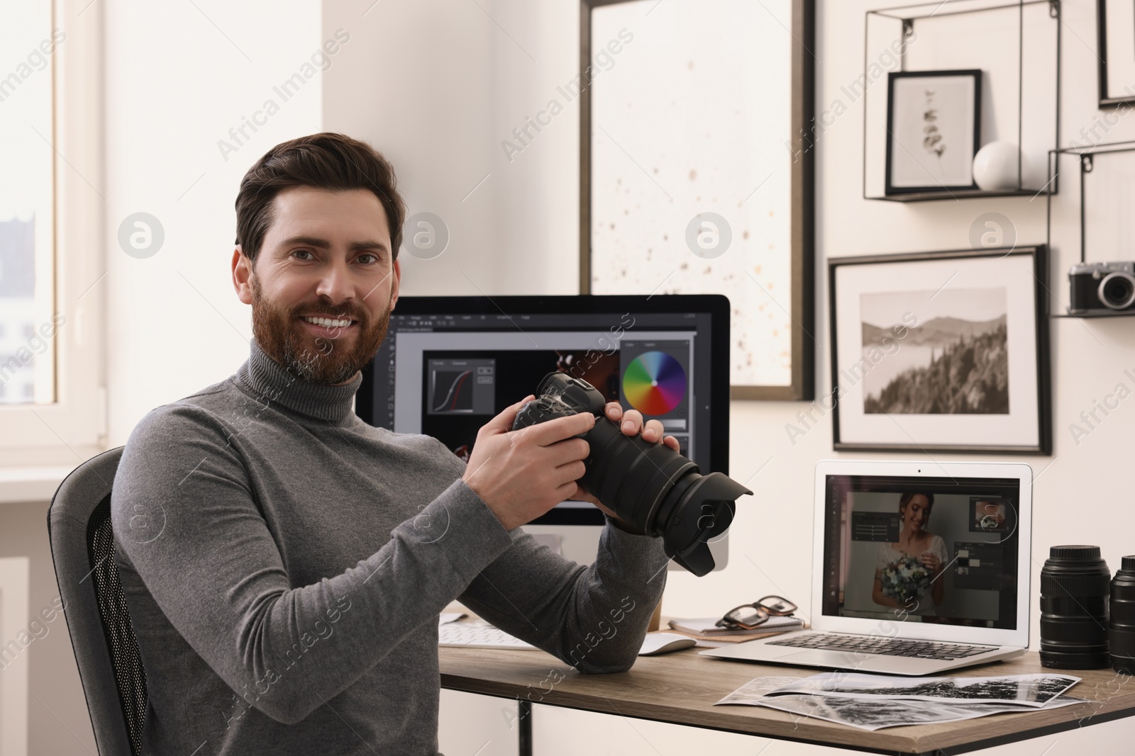 Photo of Professional photographer with digital camera at table in office