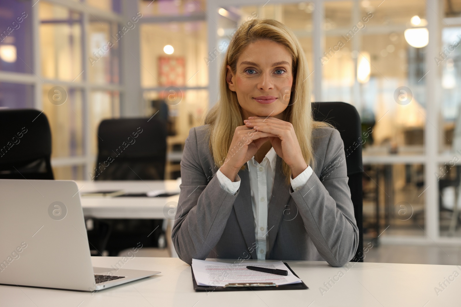 Photo of Beautiful woman at table in office. Lawyer, businesswoman, accountant or manager