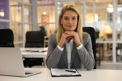 Beautiful woman at table in office. Lawyer, businesswoman, accountant or manager