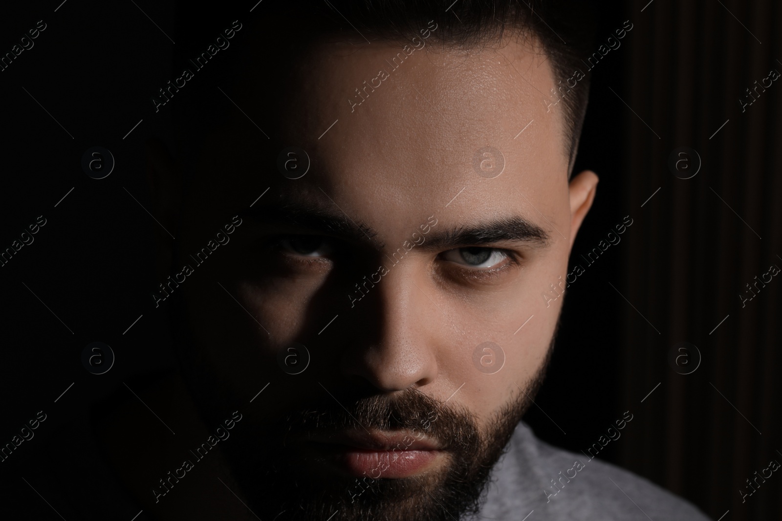 Photo of Evil eye. Man with scary eyes on black background
