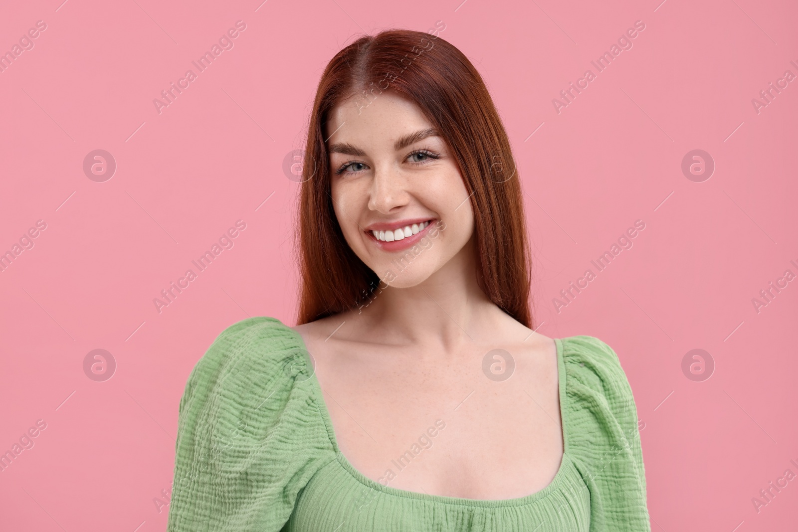 Photo of Portrait of smiling woman with freckles on pink background