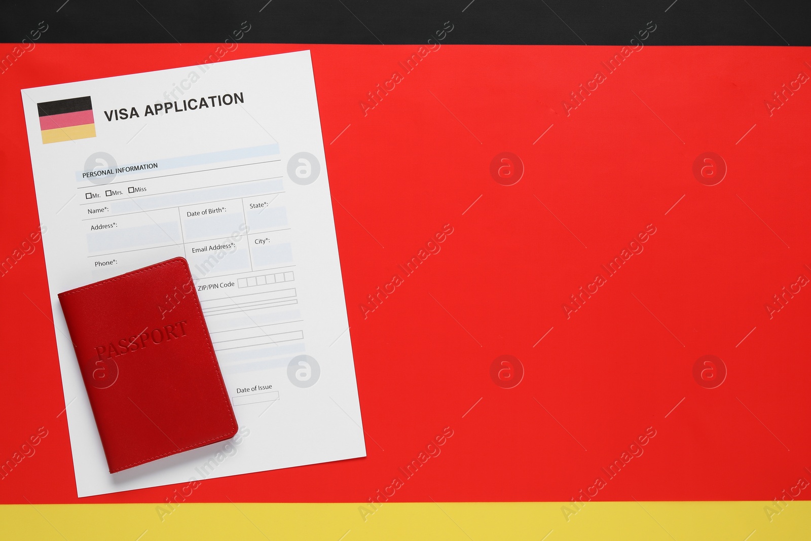 Photo of Immigration to Germany. Visa application form and passport on flag, top view. Space for text