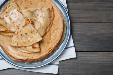 Photo of Delicious crepes on wooden table, top view. Space for text