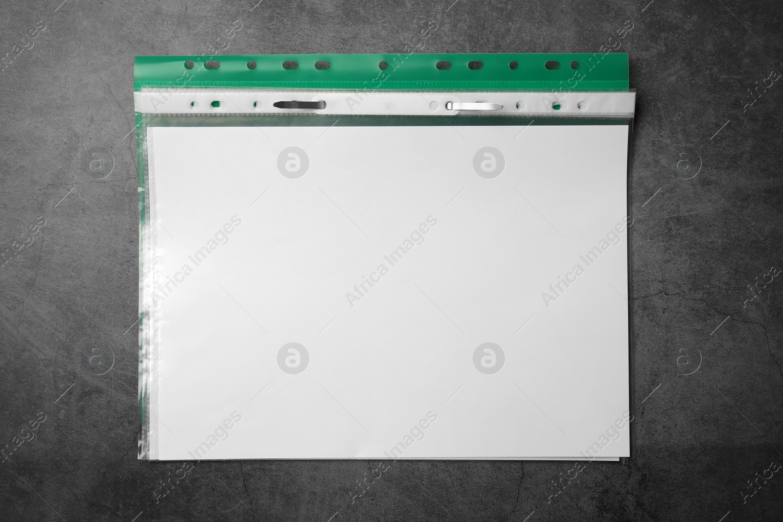 Photo of File folder with punched pockets on grey table, top view. Space for text