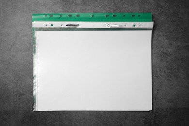 File folder with punched pockets on grey table, top view. Space for text