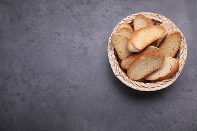 Photo of Hard chuck crackers in wicker basket on grey table, top view. Space for text