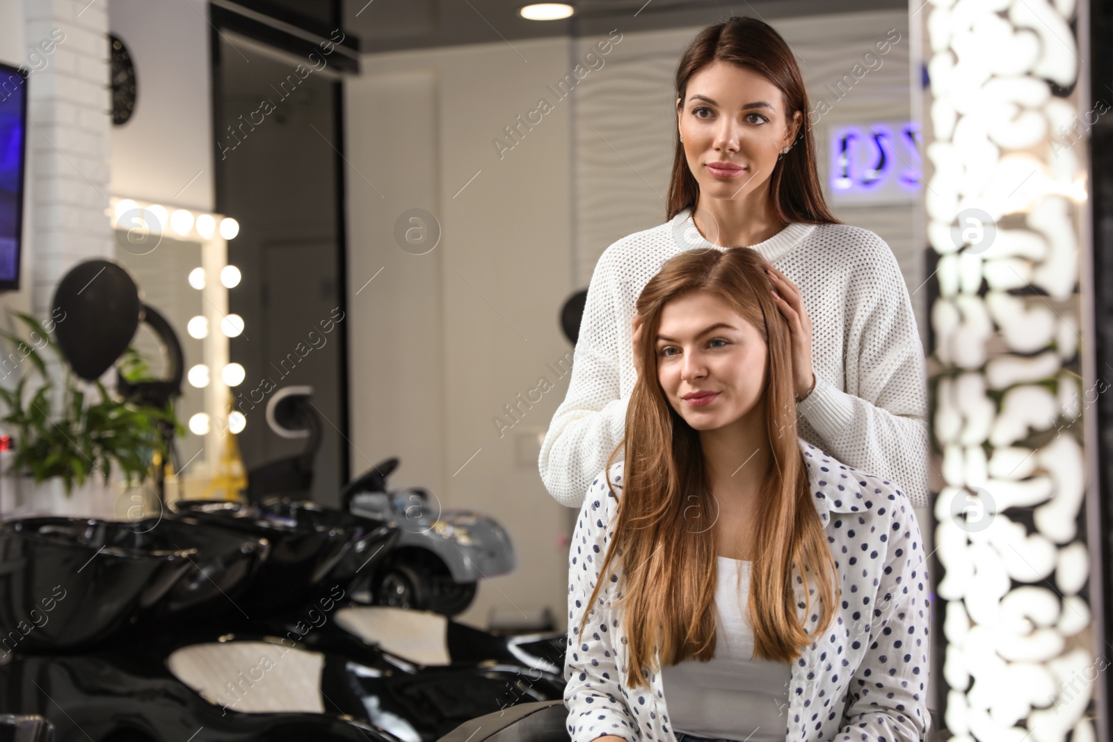 Photo of Professional hairdresser working with client in beauty salon