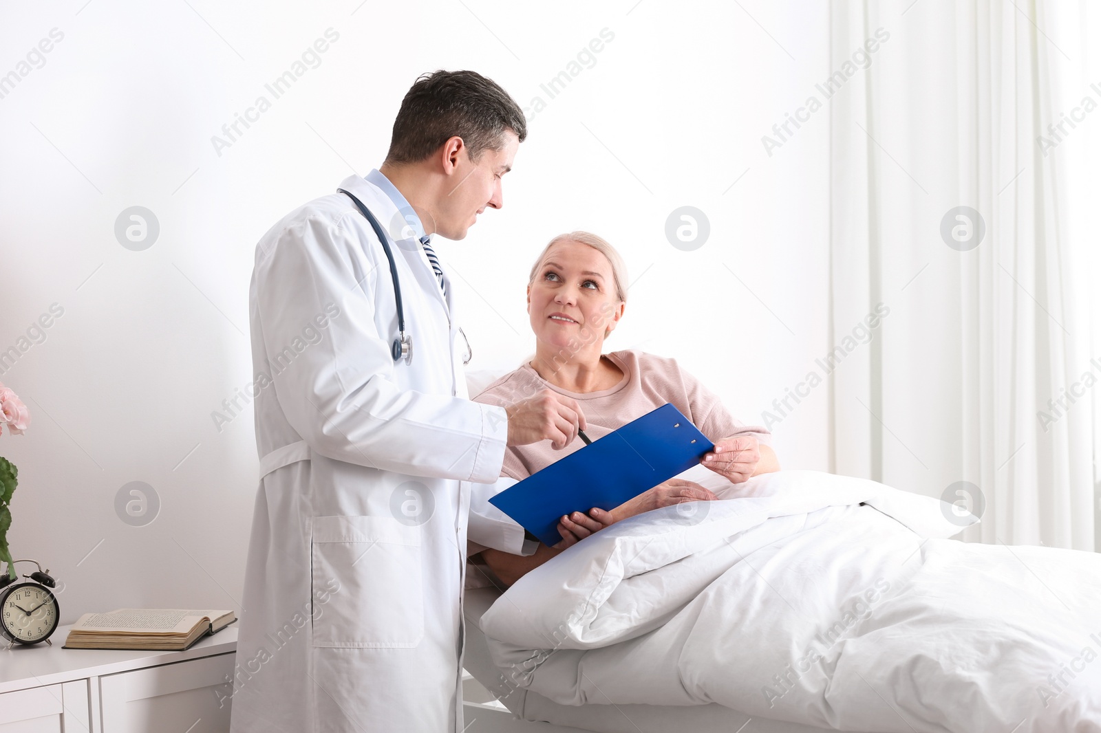 Photo of Doctor visiting his patient in hospital ward