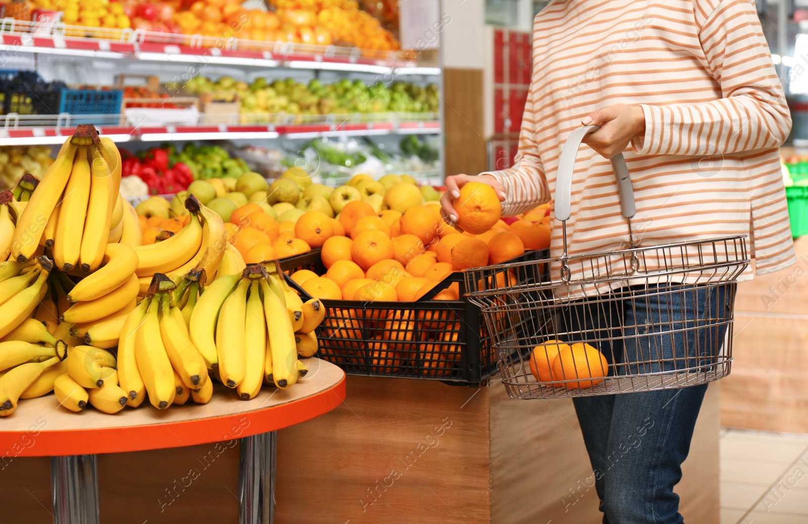 Photo of Woman with shopping basket in supermarket, closeup